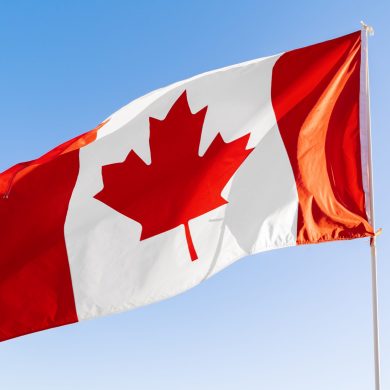 Flag of Canada waving against clear blue sky